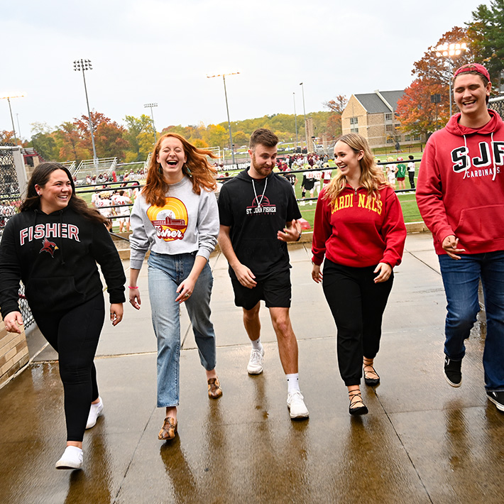 ̳ students walk on campus together with smiles.