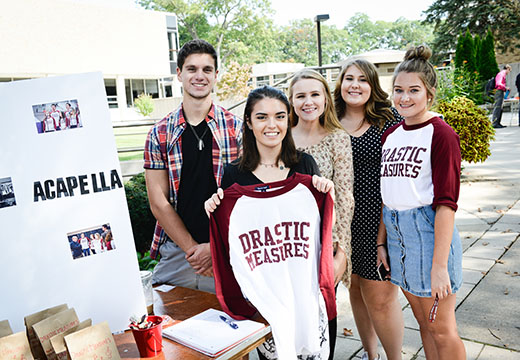 Members of ̳'s a capella group, Drastic Measures, at their Involvement Fest table.